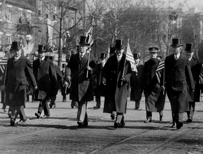 Wilson carries flag down Pennsylvania Avenue.